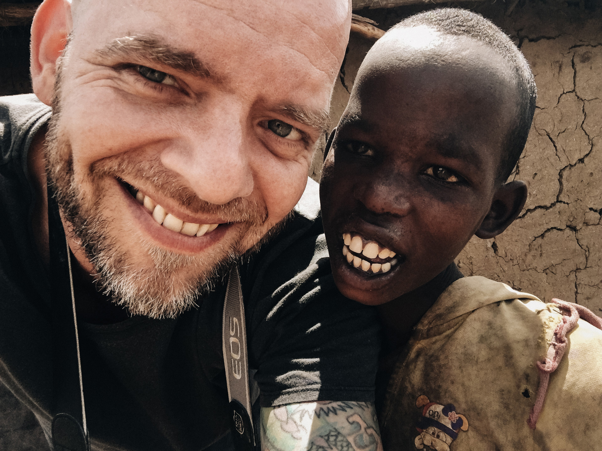 Fotojournalist und NGO Fotograf Mario Schmitt mit einem Kind des Maasai Stammes